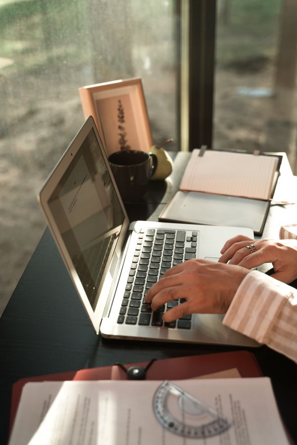 Person typing a clear website question at a laptop workspace